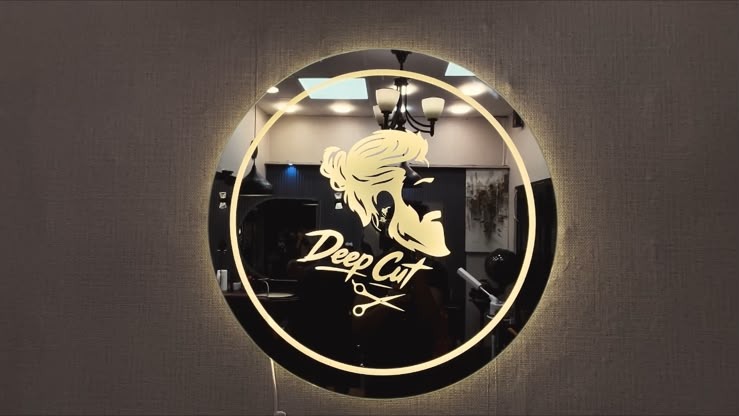 Backlit Deep Cuts logo mirror inside the shop
